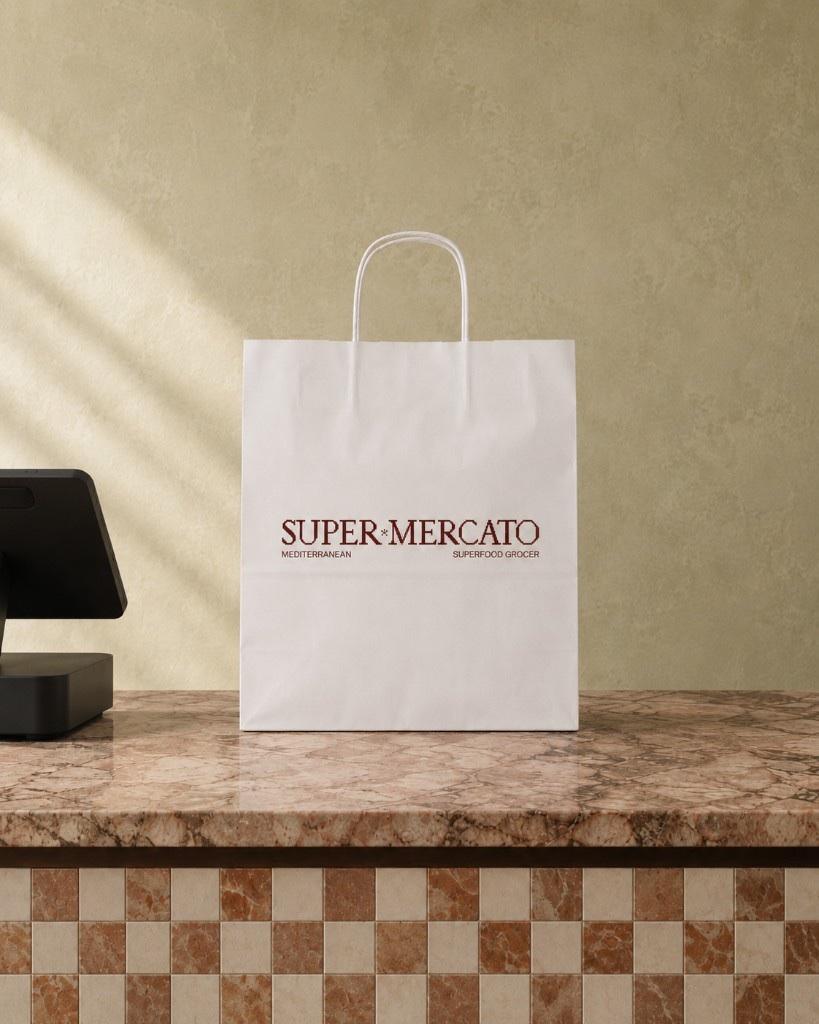 A yoghurt-white Super Mercato delivery bag on the Double Bay shop counter